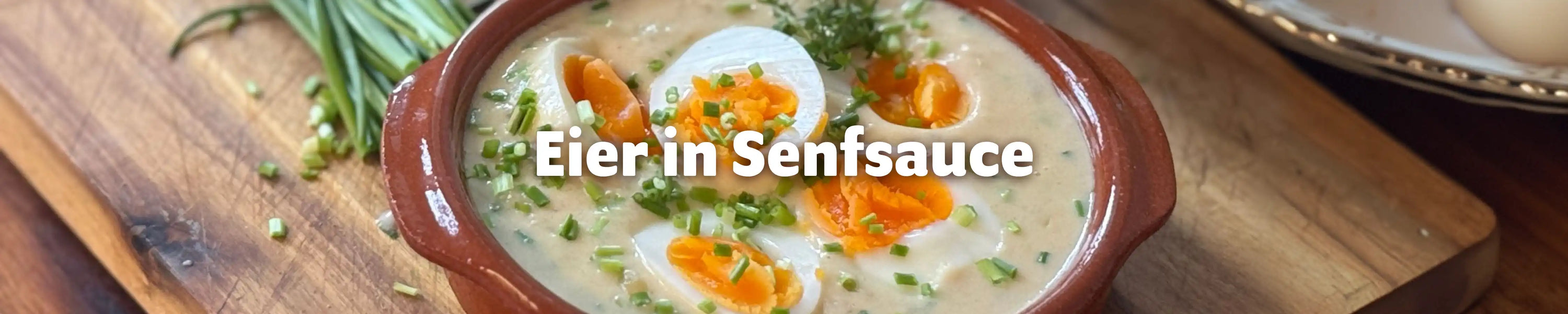 Eier in Senfsauce in einer rustikalen Tonschüssel mit frischem Schnittlauch – klassisches deutsches Rezept